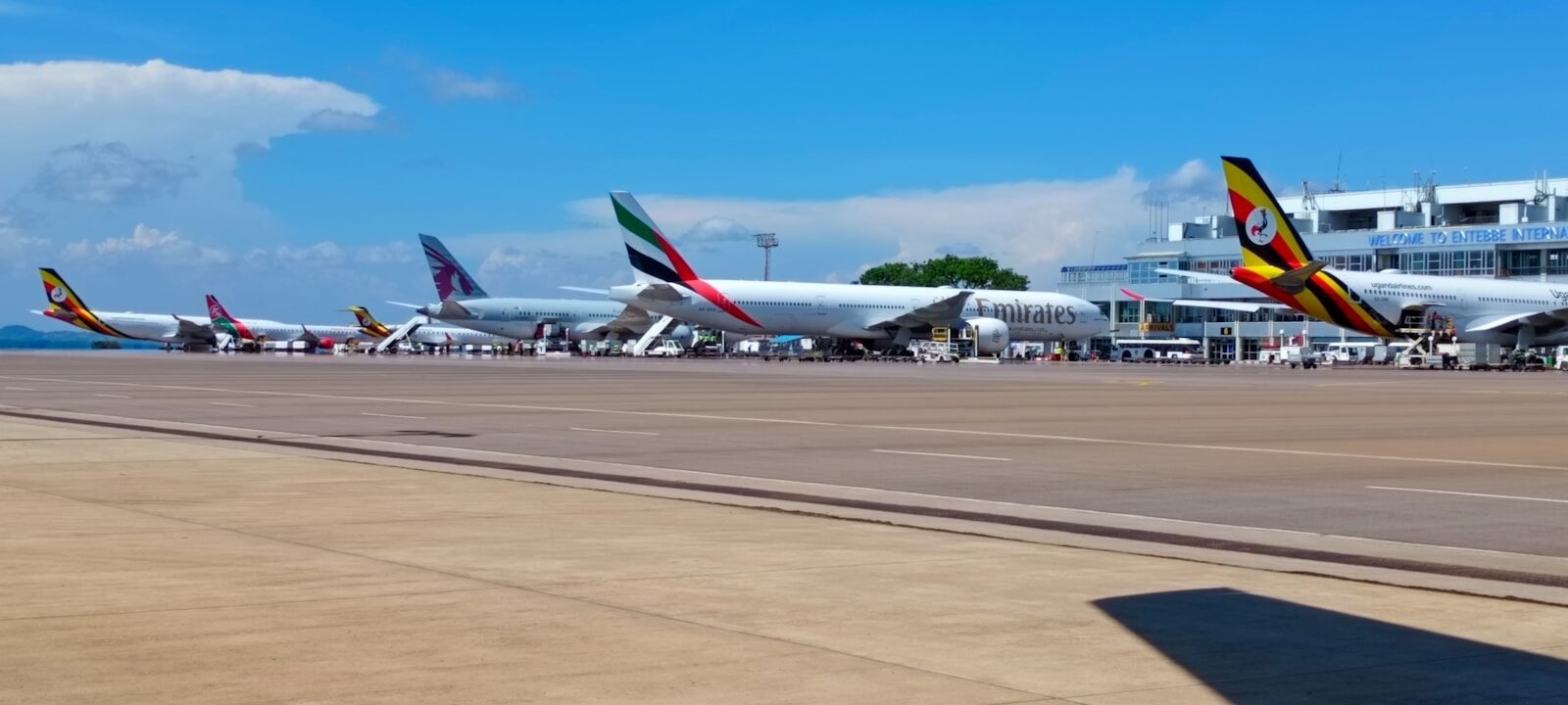 A row of parked airplanes sitting on top of an airport tarmac